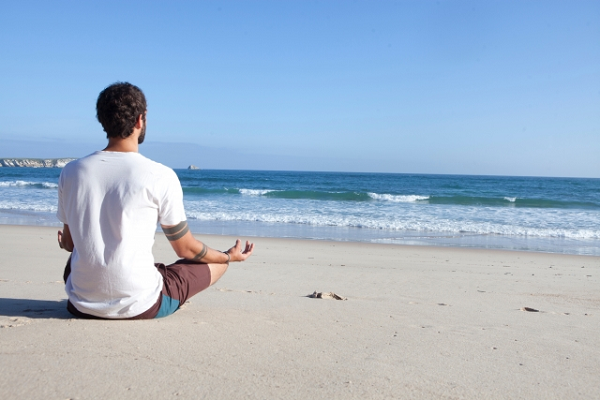 海を見て瞑想する男性の写真