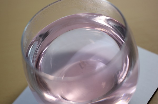 透明のグラス、ブルーマロウティーにレモン汁を入れてピンクに変化した時の写真