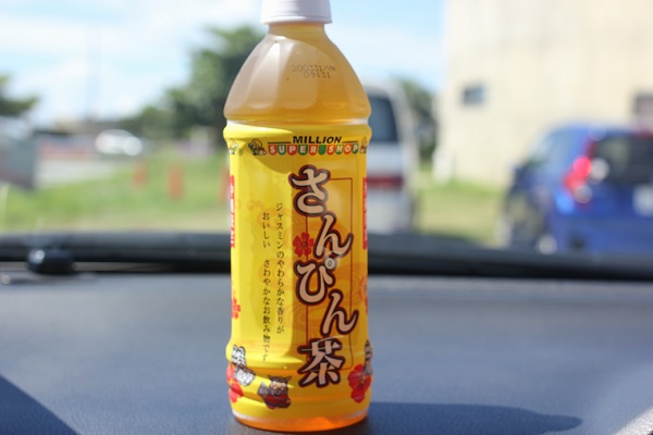沖縄で飲んでたペットボトルのさんぴん茶の裏側の写真、車のフロントに置いてる様子